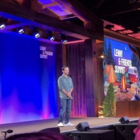 A speaker on stage against the Summit backdrop