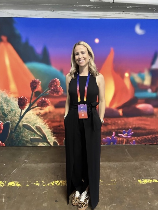An attendee standing by the campfire backdrop