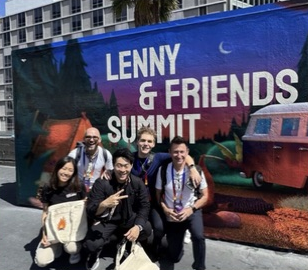 A group of attendees together beside the Summit mural