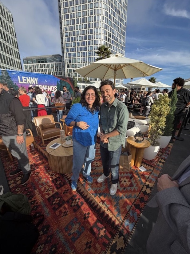 Two attendees smiling together in the outdoor lounge
